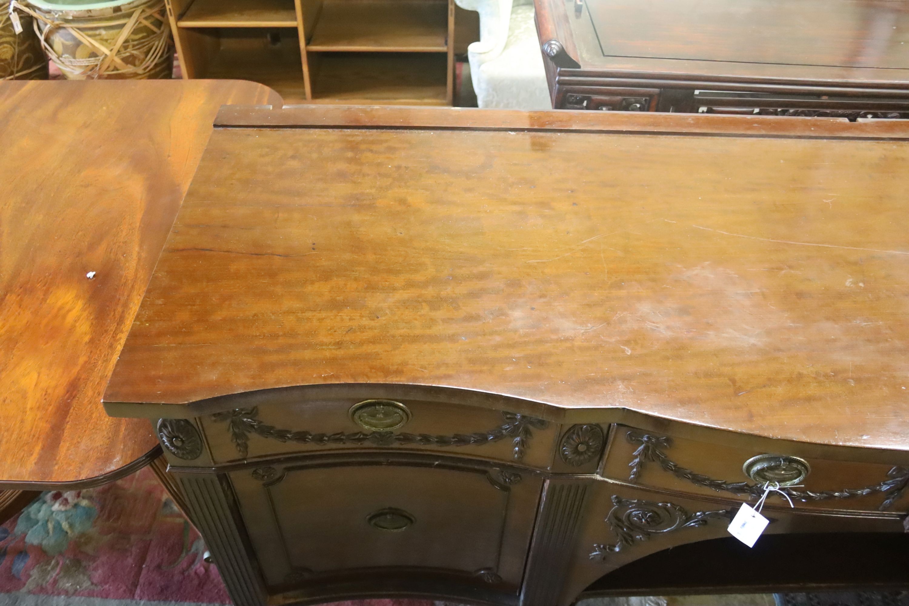 An early 20th century Adam design mahogany serpentine sideboard, length 214cm, depth 68cm, height 92cm